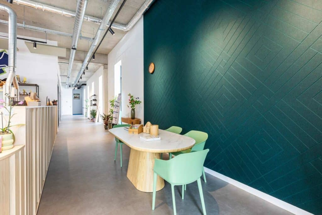 Impressie van een bedrijfspand met een wandpaneel van PET-vilt. Het paneel heeft een diepgroene tint en een V-patroon.